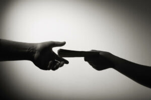 Illegal handel med flyveegern illustreres af person, der giver en anden person penge i mørke